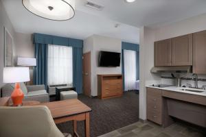 Habitación de hotel con cocina y sala de estar. en Homewood Suites By Hilton Cincinnati Midtown, en Cincinnati