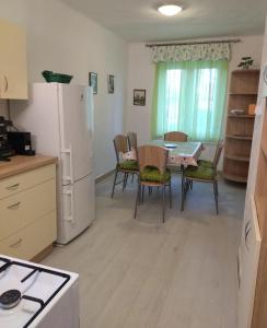 eine Küche mit einem Tisch und einem weißen Kühlschrank in der Unterkunft Jegenye Vendégház in Balatonfüred