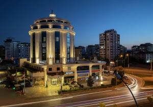 ein Gebäude mit einem Turm an der Seite einer Straße in der Unterkunft DoubleTree By Hilton Gaziantep in Gaziantep