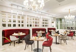ガジアンテプにあるDoubleTree By Hilton Gaziantepのテーブルと椅子、シャンデリアのあるレストラン