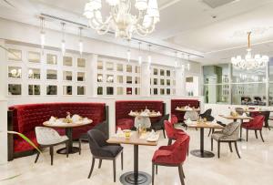 a restaurant with tables and chairs and a chandelier at DoubleTree By Hilton Gaziantep in Gaziantep