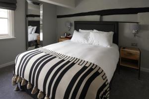 ein Schlafzimmer mit einem großen Bett und einer gestreiften Decke in der Unterkunft The Windmill in Maidstone