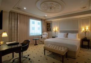 加济安泰普DoubleTree By Hilton Gaziantep的大型酒店客房设有一张床、一张书桌和一张书桌 更多31张照片