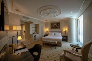 加济安泰普DoubleTree By Hilton Gaziantep的一间卧室，里面有一张床、一张沙发和一把椅子