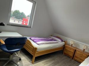 Habitación pequeña con cama, escritorio y ventana en 2 Zimmer Apartment, en Hannover