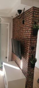 a brick wall with a flat screen tv on it at Rustic in Vir
