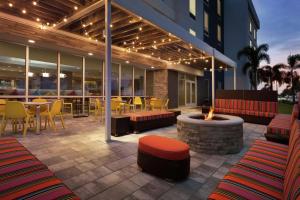 Home2 Suites By Hilton Sarasota Bradenton Airport في ساراسوتا: فناء مع حفرة نار وطاولات وكراسي