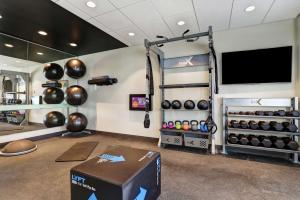 a room with a gym with a flat screen tv at Tru By Hilton Edmonton Windermere in Edmonton