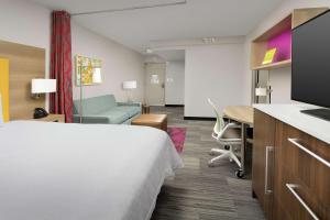 a hotel room with a bed and a desk and a table at Home2 Suites by Hilton Atlanta Midtown in Atlanta +19 photos
