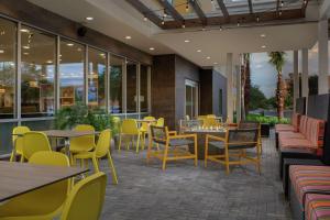 un restaurant avec des chaises, des tables et des fenêtres jaunes dans l'établissement Home2 Suites By Hilton Lakeland, à Lakeland