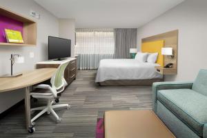 a hotel room with a bed and a desk with a computer at Home2 Suites by Hilton Atlanta Midtown in Atlanta