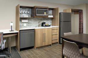 a kitchen with a refrigerator and a table and chairs at Home2 Suites By Hilton Lakeland in Lakeland