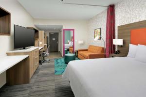 莱克兰Home2 Suites by Hilton Lakeland South Polk Parkway的一间配有床和平板电视的酒店房间