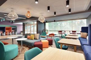 a waiting room with colorful chairs and tables at Tru By Hilton Harbison Columbia in Columbia