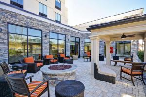 d'une terrasse avec des chaises, des tables et un foyer extérieur. dans l'établissement Hilton Garden Inn Gastonia, à Gastonia