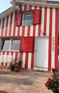 a red and white house with red shutters on it at Casiña Palmira in Finisterre