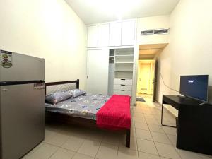 um pequeno quarto com uma cama e uma televisão em MASTER BED G19 em Dubai