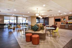 a lobby with a couch and tables and chairs at Home2 Suites By Hilton Lagrange in LaGrange