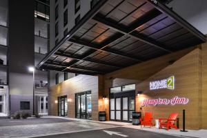坦帕Hampton Inn Tampa Downtown Channel District的一座建筑,上面有橙色椅子和标志