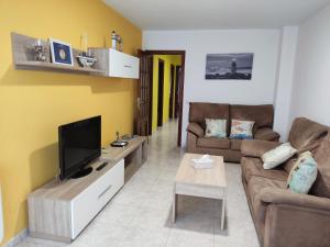 a living room with a couch and a tv at CU Apartamentos Pampin Ponte Do Porto in Ponte Do Porto