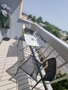 eine Terrasse mit Stühlen und einem Tisch auf dem Balkon in der Unterkunft Appartamento Valentinis 74 in Monfalcone