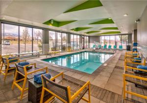 a pool in a hotel lobby with chairs and tables at Home2 Suites By Hilton Reno in Reno