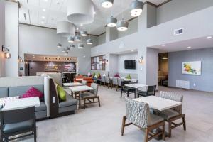 a restaurant with tables and chairs and a bar at Hampton Inn & Suites Dallas East in Dallas