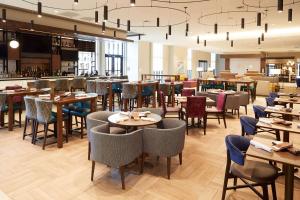 a restaurant with tables and chairs and a bar at Hilton Garden Inn Elizabethtown in Elizabethtown