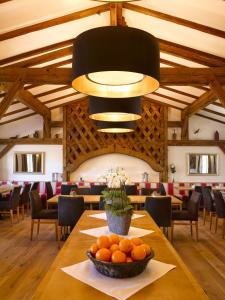 a dining room with a table with a bowl of oranges at Seehotel Waltershof in Rottach-Egern