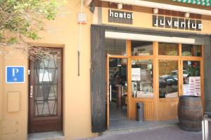 an entrance to a store with a door open at Hostal Juventus in Portbou