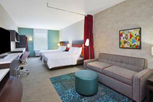 a hotel room with a bed and a couch at Home2 Suites By Hilton Holland in Holland