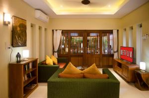un salon avec deux canapés verts et une télévision dans l'établissement Romantic 1 Bed Villa with Pool - 150 mtrs to beach, à Koh Samui 