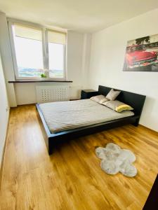a bedroom with a large bed and a wooden floor at Apartament na Orchidei in Bielsko-Biała