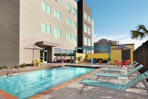 a swimming pool with lounge chairs and a building at Tru by Hilton Webster Houston NASA in Webster