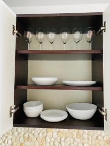 a shelf with bowls and wine glasses on it at Apartament na Orchidei in Bielsko-Biała