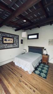 Schlafzimmer mit einem Bett und Holzboden in der Unterkunft Exquisito departamento “Boutique” in Balcarce