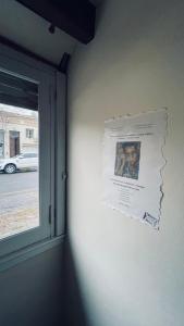 ein Plakat an einer Wand neben einem Fenster in der Unterkunft Exquisito departamento “Boutique” in Balcarce