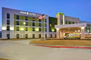 普莱诺Home2 Suites Plano Legacy West的前面有旗帜的医院建筑