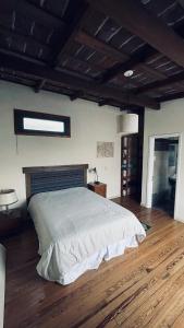 ein Schlafzimmer mit einem großen Bett und Holzboden in der Unterkunft Exquisito departamento “Boutique” in Balcarce