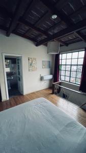 Schlafzimmer mit einem Bett, einem Schreibtisch und Fenstern in der Unterkunft Exquisito departamento “Boutique” in Balcarce