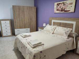 a bedroom with a bed with towels on it at CU Apartamentos Pampin Ponte Do Porto in Ponte Do Porto