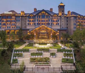 a large building with a fountain in front of it at Hilton Wenan in Langfang