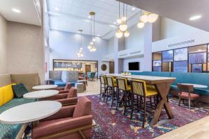 GuymonHampton Inn And Suites Guymon的设有桌椅和酒吧的大堂