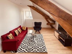 a living room with a red couch and a chair at Résidence Paul Bert in Tarbes