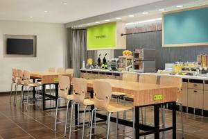 een vergaderruimte met tafels en stoelen en een keuken bij Home2 Suites By Hilton Brooklyn Park Minneapolis in Brooklyn Park