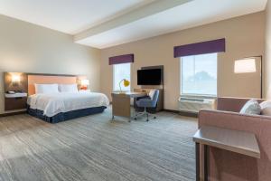 GuymonHampton Inn And Suites Guymon的一间带床、书桌和电视的酒店房间