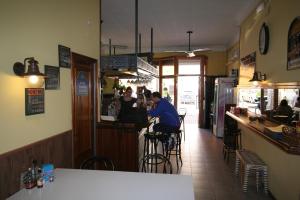 a group of people sitting at a bar in a restaurant at Hostal Juventus in Portbou