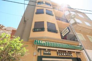 a tall building with a sign in front of it at Hostal Juventus in Portbou
