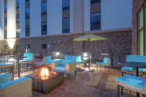 een patio met tafels en stoelen en een vuurplaats bij Hampton Inn Weston, WV in Weston