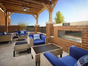 een patio met blauwe meubels en een stenen open haard bij Hampton Inn Chattanooga East Ridge in Chattanooga